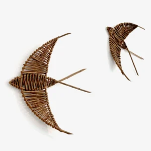 a pair of willow woven swallows hung on a white wall