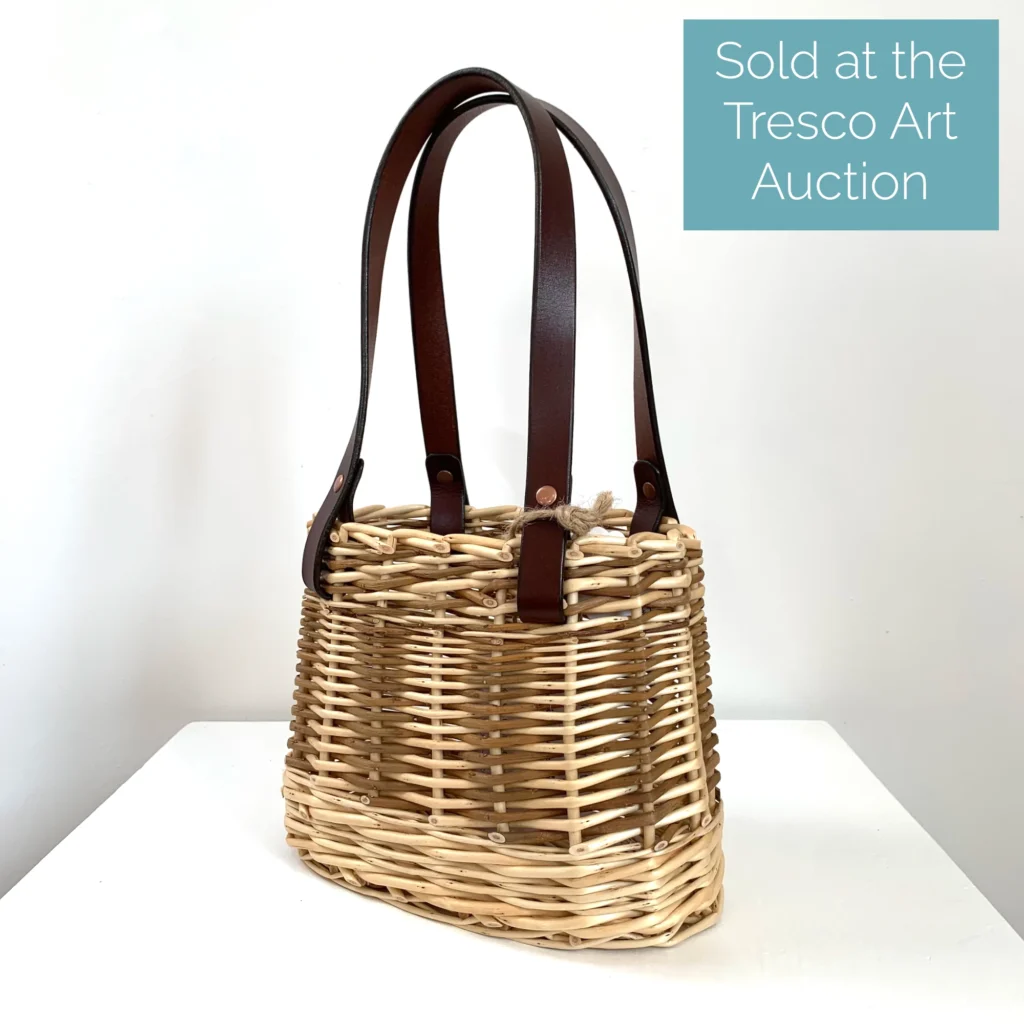 a thumbnail image of a willow basket bag with leather handles and the words sold at the tresco art auction