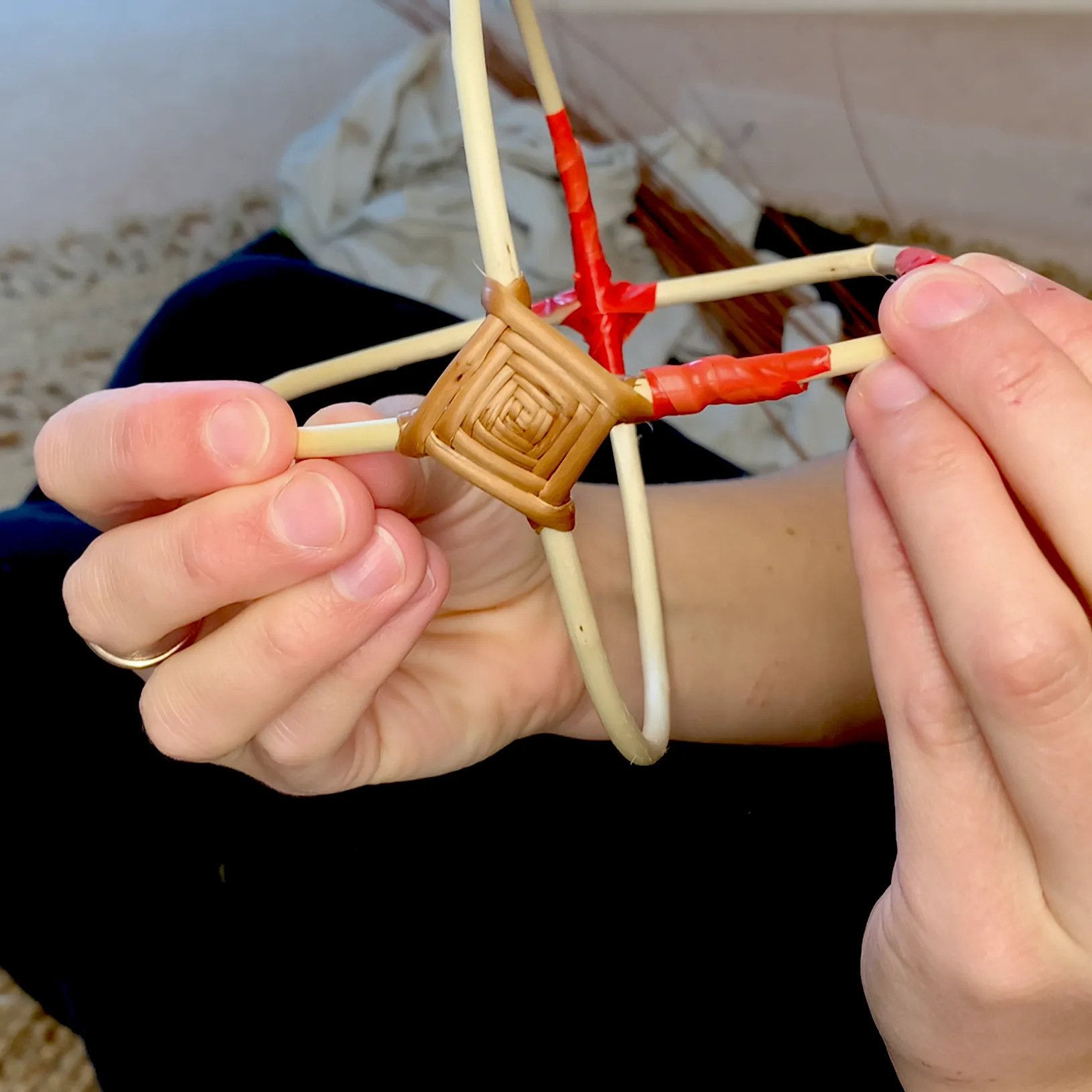 willow frame basket tutorial video still showing a close up of the 'gods eye' weave