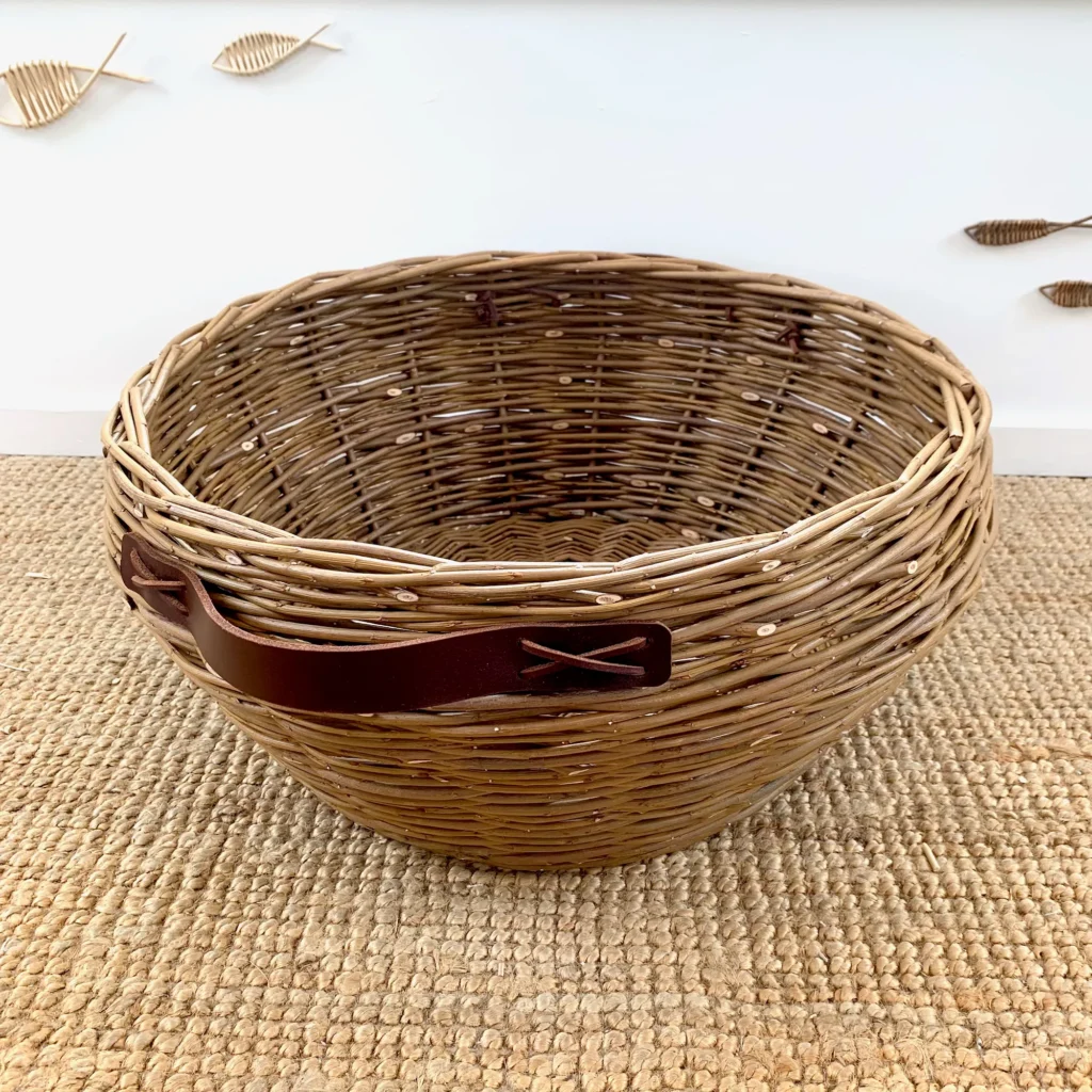 a large willow basket with leather handles