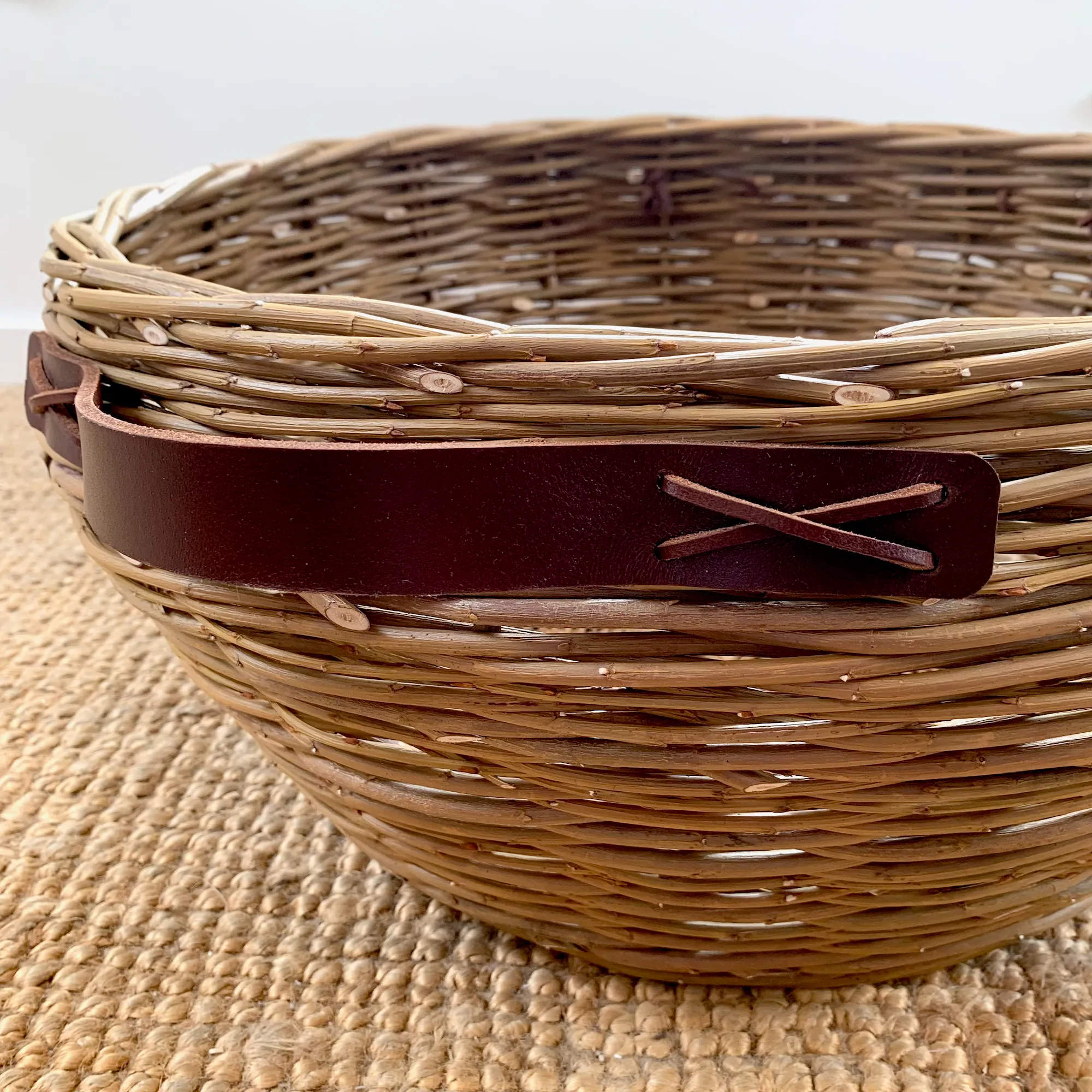 close up of a large willow basket with leather handles
