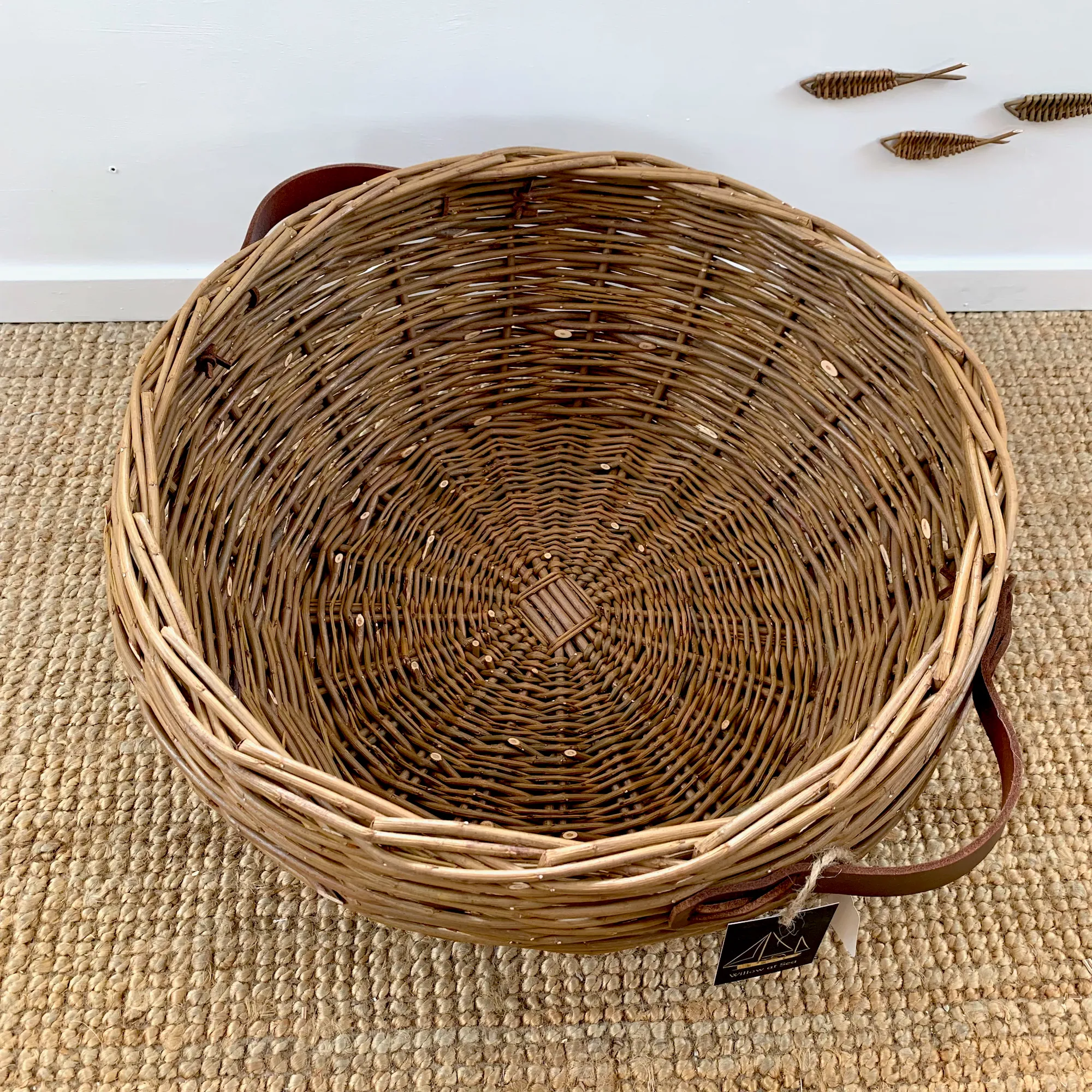 a large willow basket with leather handles top down view