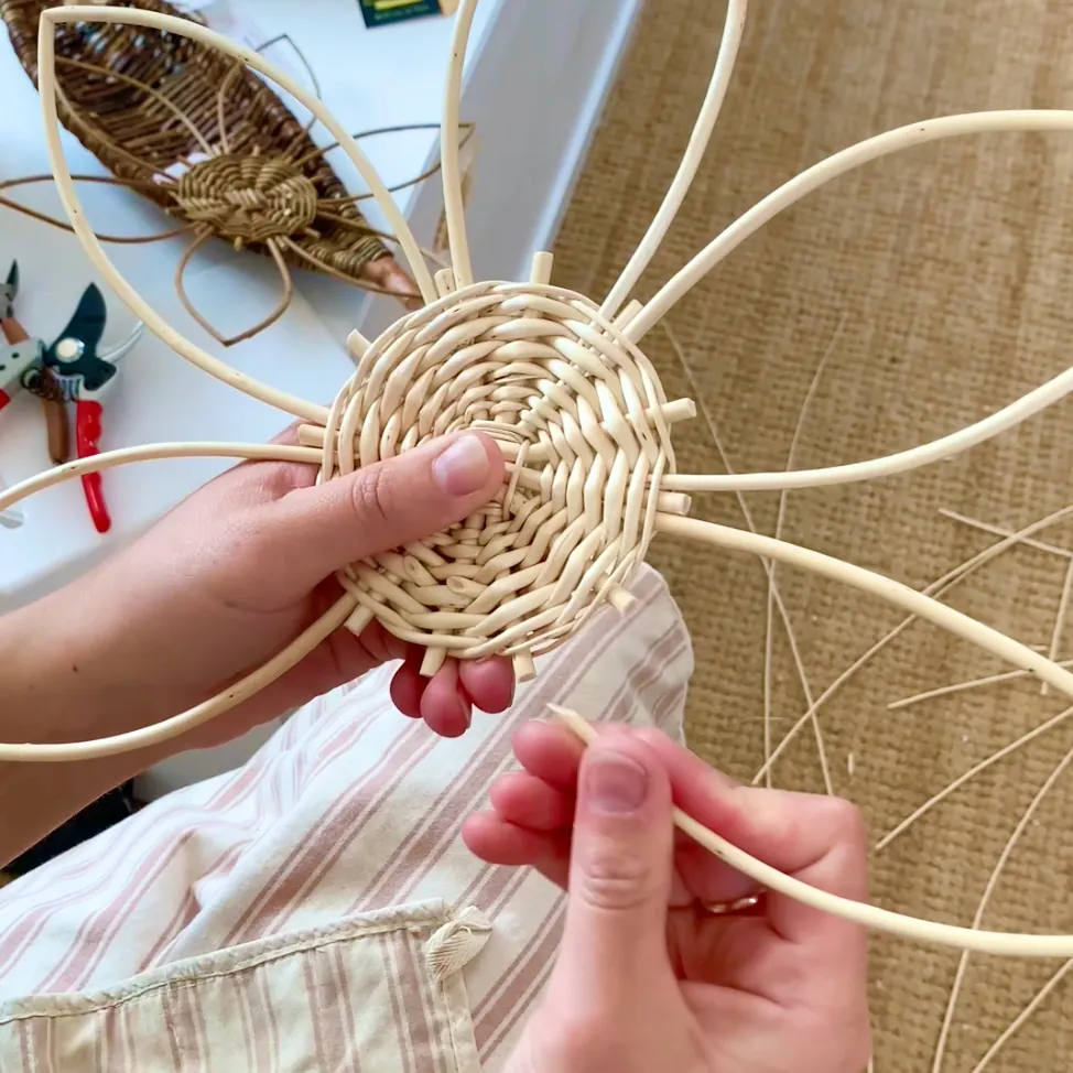 willow weaving tutorial video still showing petals being attached to a flower centre